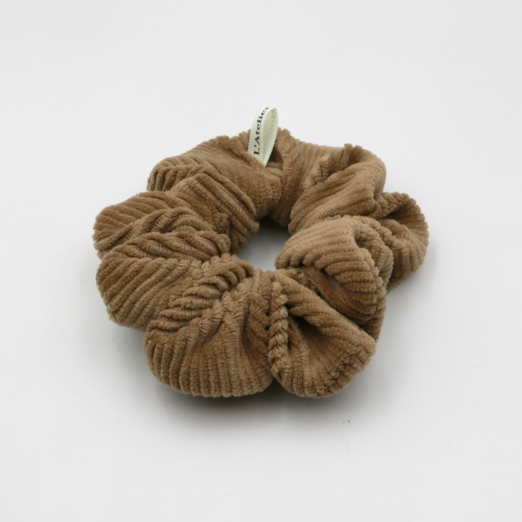 Corduroy Brown scrunchie with a brand tag on a white background