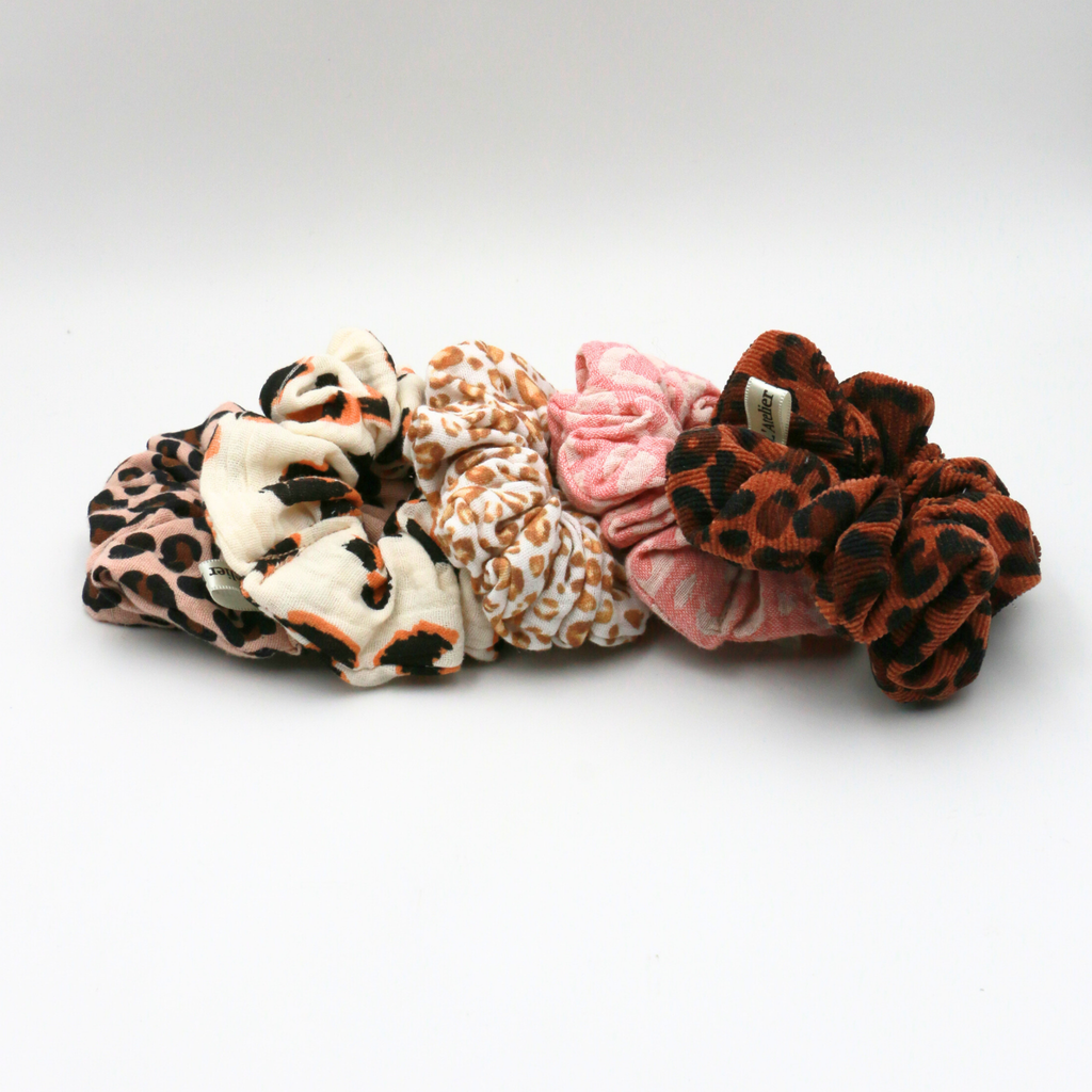 Set of five patterned scrunchies on a white background
