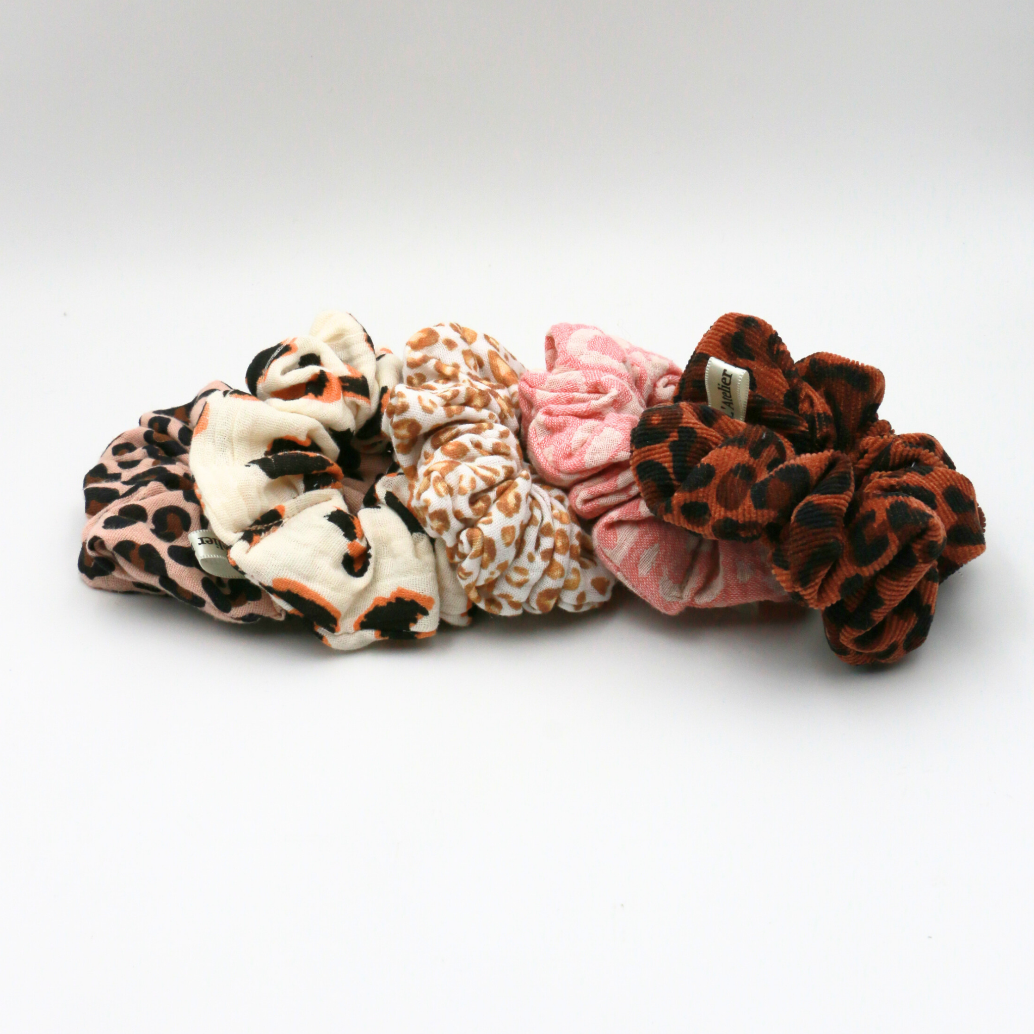 Set of five patterned scrunchies on a white background