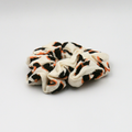 White scrunchie with black and orange pattern on a white background