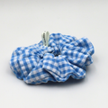 Blue and white checkered scrunchie on a light gray background