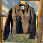 Denim jacket with floral embroidery on a wooden fence