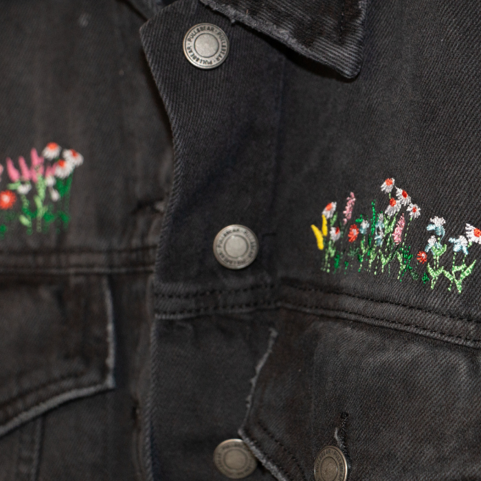 Black denim jacket with floral embroidery on the sleeves