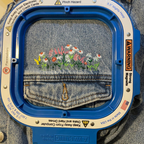 Embroidery hoop with denim fabric and floral design on a denim background